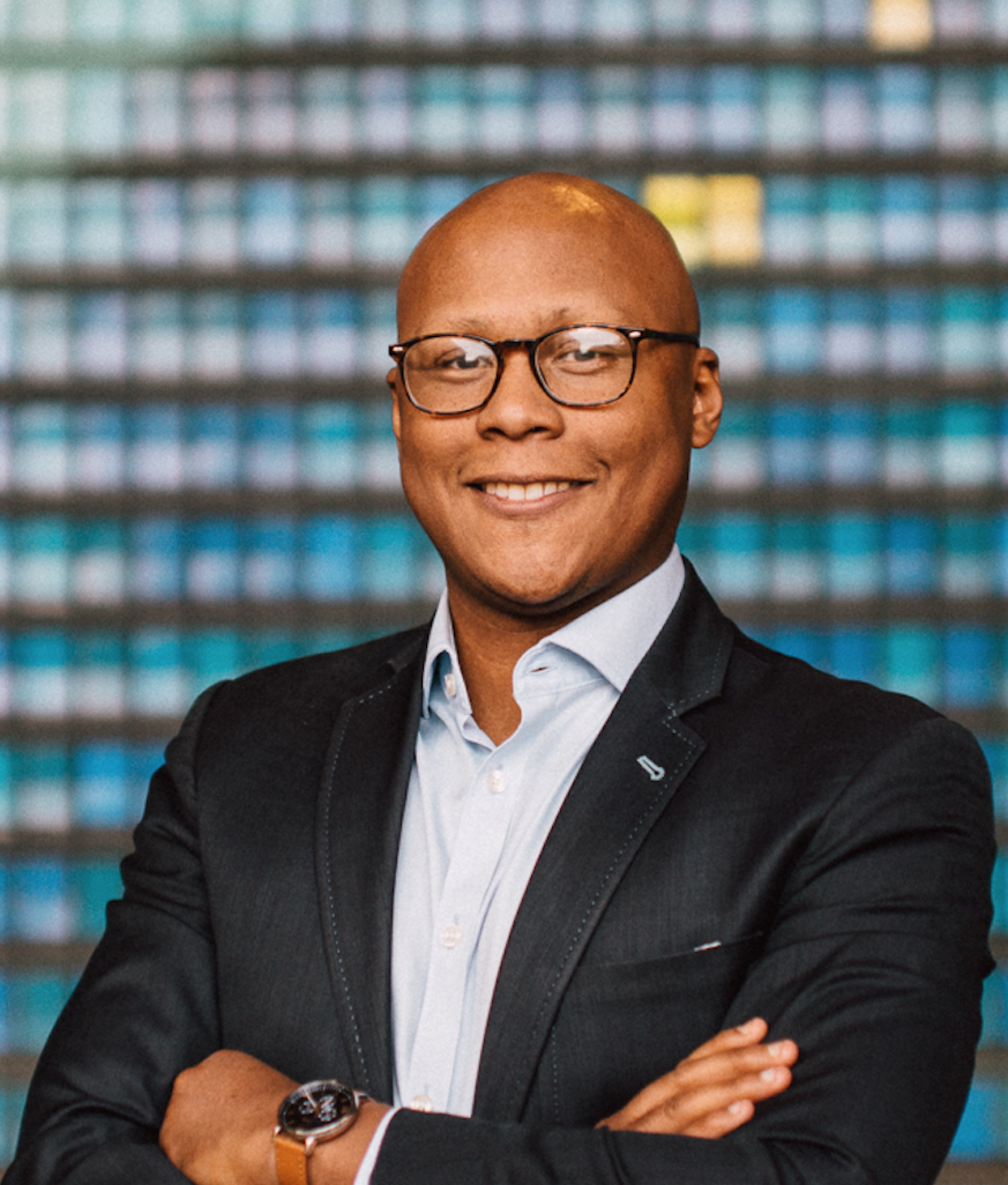 Jay Finch headshot wearing glasses and a blazer with a blue collared shirt.
